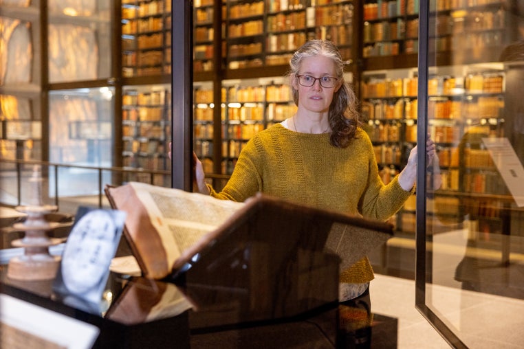 Hatcher opens the specially made, humidity-monitored glass case containing the Gutenberg Bible and a a 1,250-year-old print of Buddhist prayers. 
