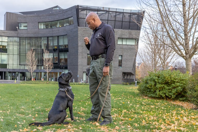Blue and handler Charles Hebron pictured in front of Yale Health
