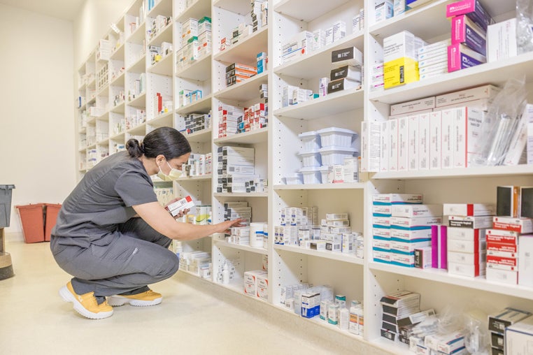 Woman searching for a prescriptions on a shelf