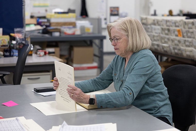 Image of Barbara Botti, from the Registrar’s Office, comparing a Yale College diploma against the latest information in the university’s records