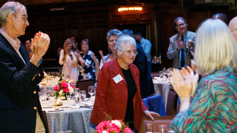 Honorees, guests, and senior leaders stand for Patricia Kane, Yale’s 55-year honoree, after her tribute video was screened.