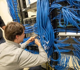 Kevin O'Donnell from Network Engineering organizing data closet cabling.