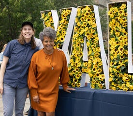 Group of staff posing in front of a Yale sign of sunflowers.