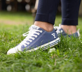 Staff member posing with their Yale branded shoes.