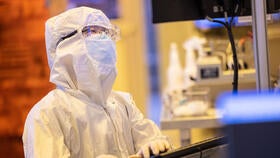 A scientist in a full body cleansuit, working in the university cleanroom