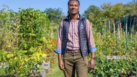 Jordan M. Williams, the West Campus Farm and Operations Manager for Yale Hospitality, standing in front of raised beds on the farm.