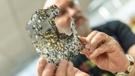 Person examining a piece of meteorite.